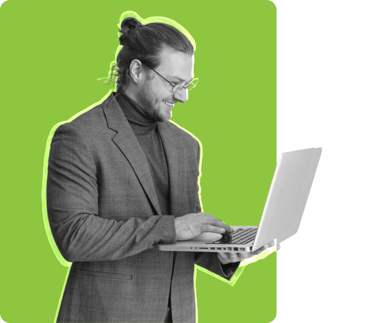 A man in a suit is focused on his laptop, engaged in work or a professional task.